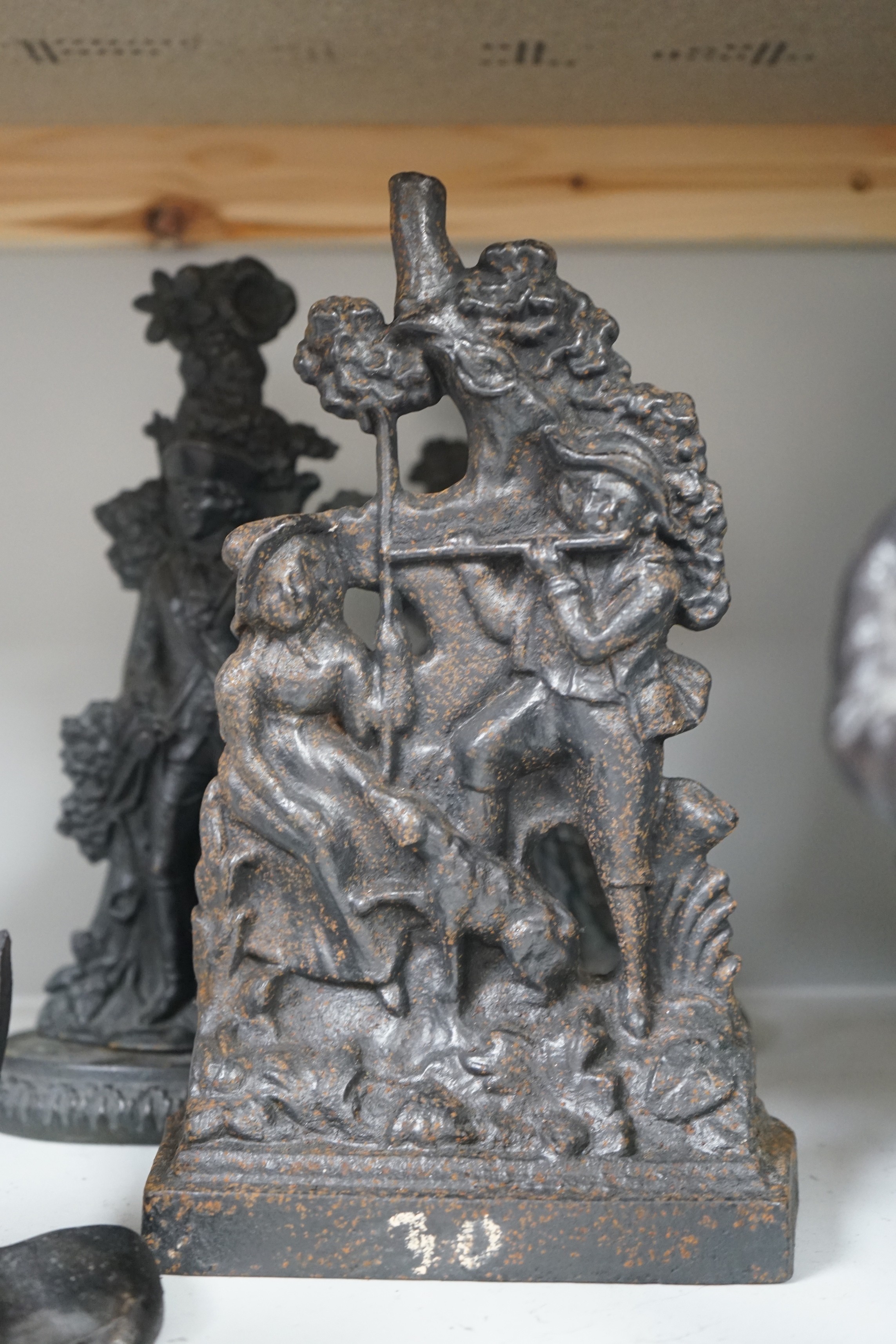 Six assorted cast iron Victorian door stops, to include a sunken anchor, one painted later, tallest 27cm